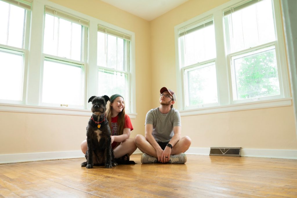 Ehepaar und ihr Hund sitzen in einem leeren Haus