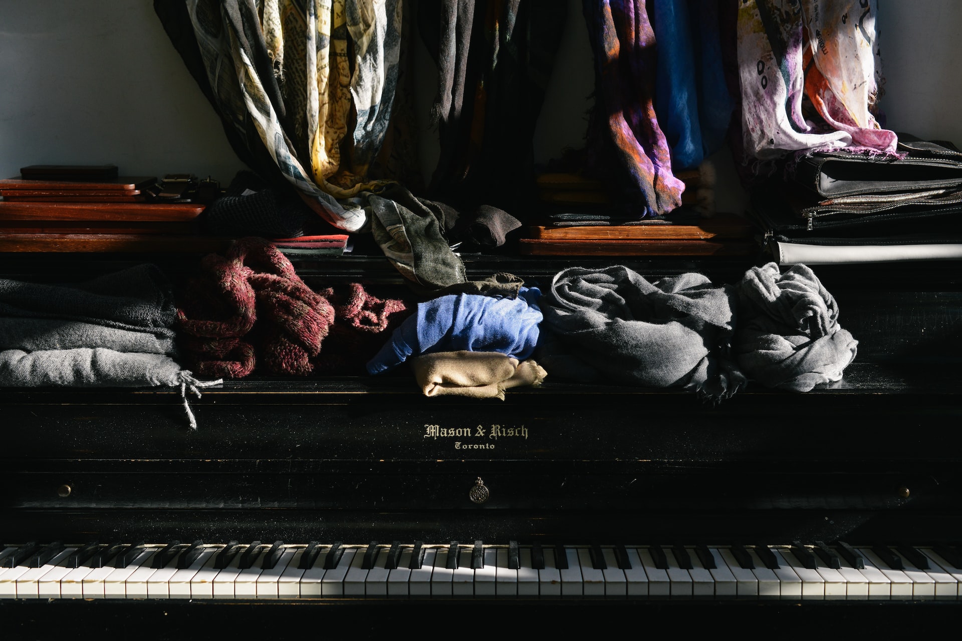 Stapel von Kleidung auf einem Klavier