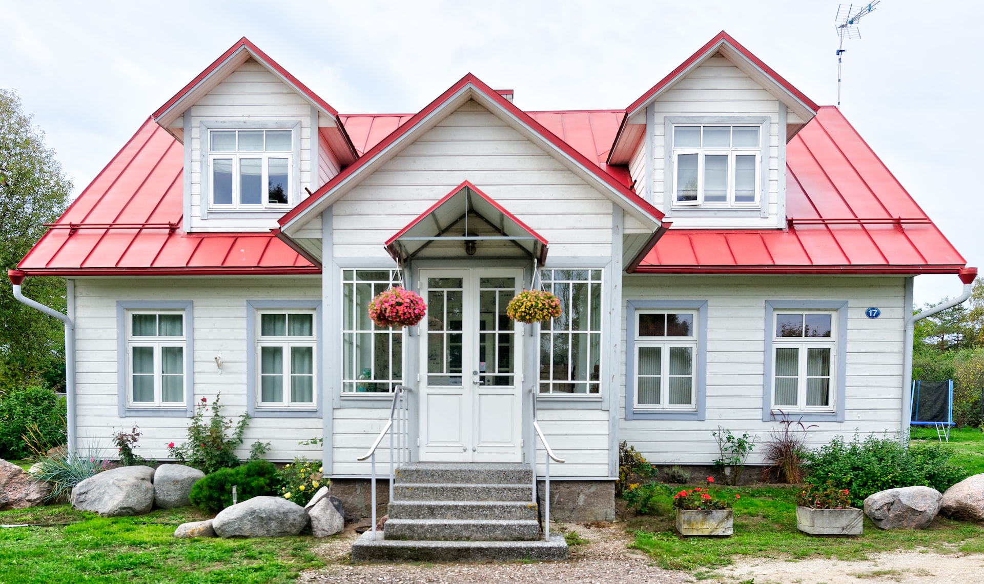 Ein weißes Holzhaus mit rotem Dach