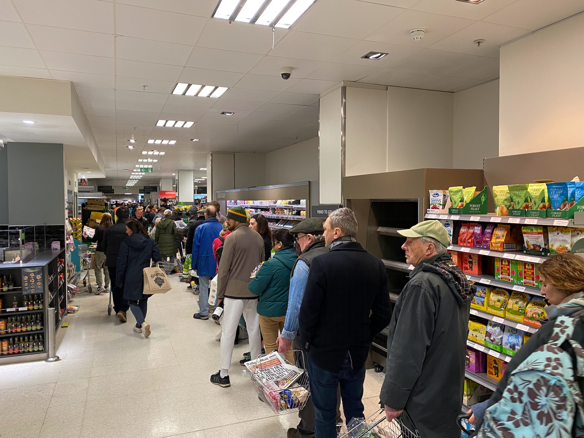 Menschen stehen im Supermarkt Schlange