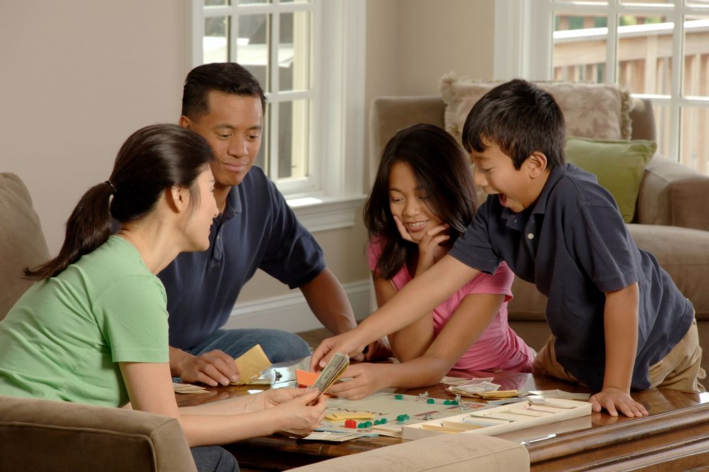 Vierköpfige Familie spielt ein Brettspiel