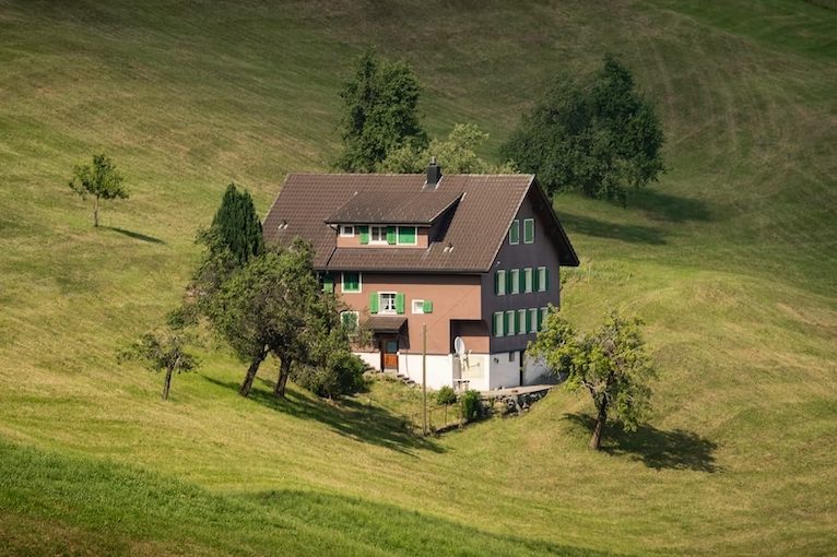 Eine malerische Landschaft mit Wiesen und einem Haus in der Mitte