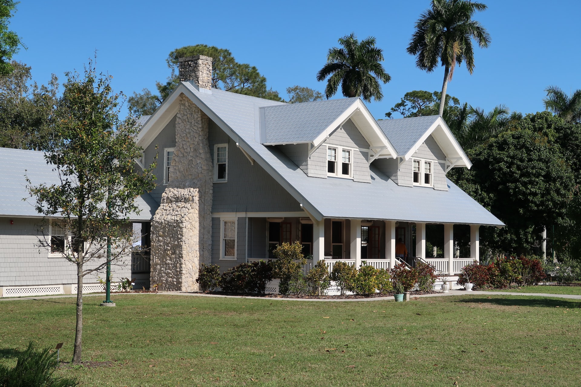 Einstöckiges Einfamilienhaus mit grauem Dach und Garten