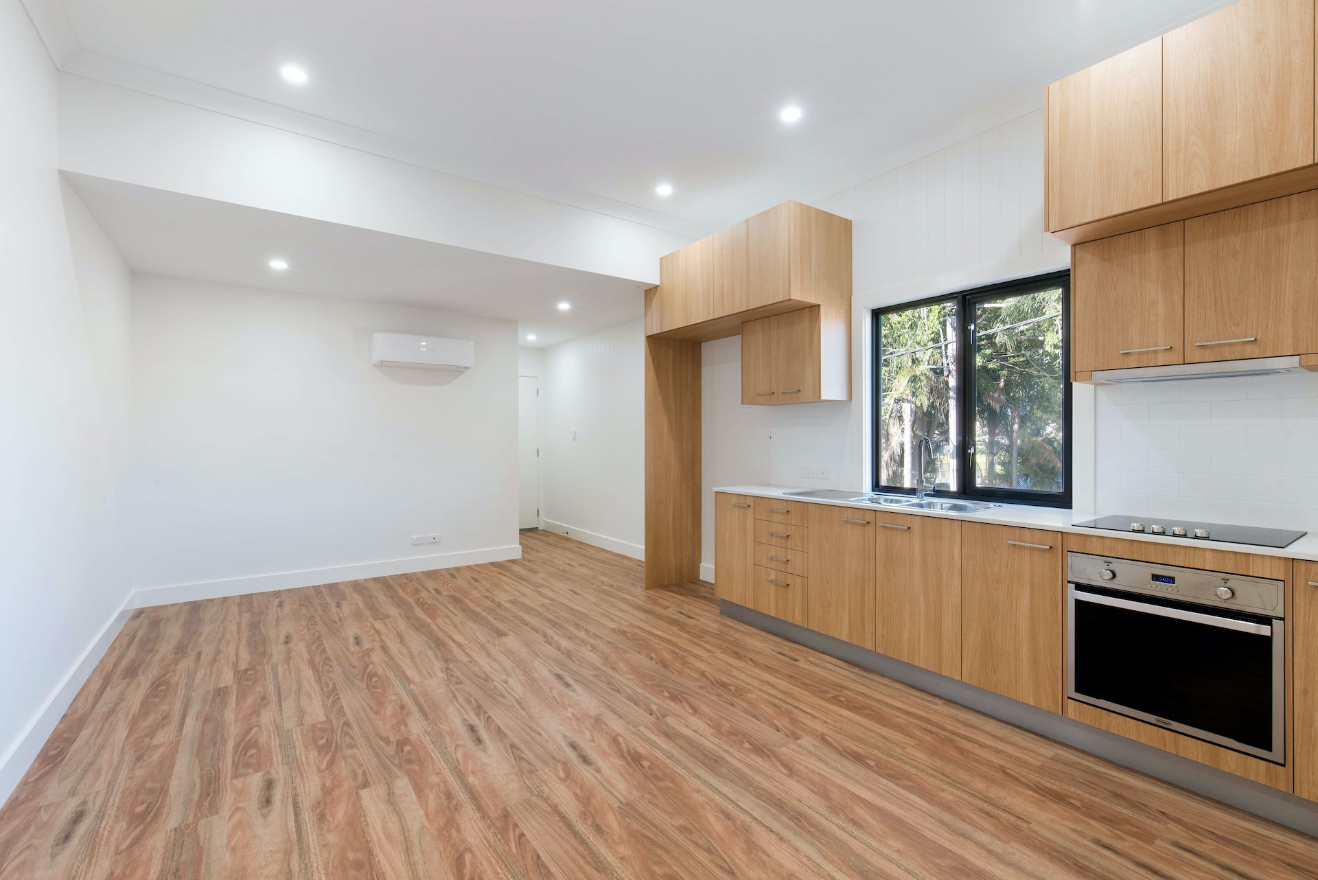 Wohnung mit offener Modulküche, großen Fenstern, Holzfußboden und Zwischendecke