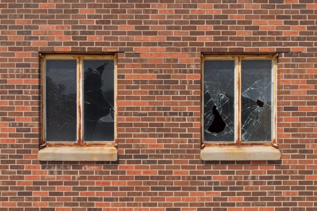 Beschädigte Fenster in einem Haus mit Ziegelfassade